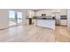 Bright kitchen with white cabinets, stainless steel appliances, a center island, and sliding glass doors at 739 N Deer Park St, Watkins, CO 80137