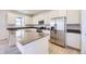 Modern kitchen featuring white cabinets, stainless steel appliances, an island with grey countertop, and hardwood floors at 739 N Deer Park St, Watkins, CO 80137