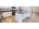 Stylish kitchen featuring white cabinets, stainless steel appliances, a center island, and bright lighting at 739 N Deer Park St, Watkins, CO 80137