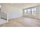 Bright living room with hardwood floors, white walls, and large windows offering natural light at 739 N Deer Park St, Watkins, CO 80137