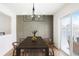 Well-lit dining area with a modern chandelier and sliding glass doors to the patio at 3643 S Mobile Way, Aurora, CO 80013