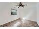 This airy bedroom features wood flooring, a ceiling fan, and natural light from the window at 18347 E Nassau Dr, Aurora, CO 80013