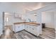 Bright kitchen with white cabinets, wood-look flooring, and an open view to the living area at 18347 E Nassau Dr, Aurora, CO 80013