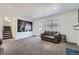 Bright living room with plush carpet, a cozy couch, and stairs leading up to the next level at 18347 E Nassau Dr, Aurora, CO 80013