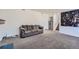 Open living room featuring neutral carpet, a modern art piece, and easy access to the stairs at 18347 E Nassau Dr, Aurora, CO 80013