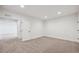 Bright bedroom featuring neutral carpeting, white walls, and a door leading to an additional room at 5537 Riverbend Ave, Firestone, CO 80504