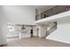Open-concept kitchen with white cabinets, an island, and a modern staircase leading upstairs at 5537 Riverbend Ave, Firestone, CO 80504