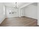 Bright living area boasting light wood floors, a stylish chandelier, and a view of the outdoors at 5537 Riverbend Ave, Firestone, CO 80504