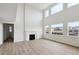 Soaring ceilings and a cozy fireplace in this light-filled living room with expansive windows at 5537 Riverbend Ave, Firestone, CO 80504