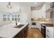 Eat-in kitchen featuring white countertops, pendant lights, stainless appliances, and stylish cabinetry at 6209 Stable View St, Castle Pines, CO 80108