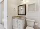 Compact bathroom with white vanity, toilet, medicine cabinet and modern fixtures at 3121 S Estes St, Lakewood, CO 80227