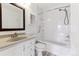 Well-lit bathroom with a white vanity, toilet, and a shower-tub combination with grab bars at 3121 S Estes St, Lakewood, CO 80227