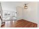 Dining room boasting hardwood floors, and a contemporary lighting fixture with adjoining carpeted living area at 3121 S Estes St, Lakewood, CO 80227