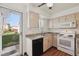 This sunny kitchen showcases stainless steel sink and appliances; it looks out onto a large backyard at 3121 S Estes St, Lakewood, CO 80227