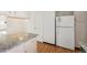 Well-lit kitchen features granite countertops, white appliances, and ample cabinet space at 3121 S Estes St, Lakewood, CO 80227