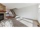 Bright living room featuring a cozy fireplace with stone surround and staircase at 3121 S Estes St, Lakewood, CO 80227
