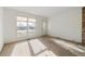 Bright living room features large window, front door, and cozy carpet flooring at 3121 S Estes St, Lakewood, CO 80227