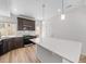 Modern kitchen featuring white quartz island, wood cabinets, stainless appliances, and wood floors at 1169 Highview Dr, Erie, CO 80516