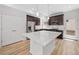 Modern kitchen featuring white quartz island, wood cabinets, stainless appliances, and wood floors at 1169 Highview Dr, Erie, CO 80516