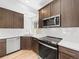 Modern kitchen featuring stainless appliances, wood cabinets, white quartz countertop and wood floors at 1169 Highview Dr, Erie, CO 80516