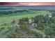 Aerial view of the sprawling property surrounded by lush greenery, trees and a picturesque landscape at 10914 Remmick Ridge Rd, Parker, CO 80134