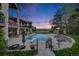 Spacious backyard with a large in-ground pool, lounge chairs, landscaped accents, and elegant two-story home at dusk at 10914 Remmick Ridge Rd, Parker, CO 80134