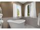 Elegant bathroom featuring a freestanding tub with stylish fixtures, large windows, and calming neutral colors at 10914 Remmick Ridge Rd, Parker, CO 80134