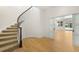 Foyer with curved staircase and hardwood floors leading to an open area with sliding doors to a pool and outdoor space at 10914 Remmick Ridge Rd, Parker, CO 80134