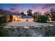 Elegant home featuring manicured landscaping, a circular driveway, and a grand facade enhanced by the evening light at 10914 Remmick Ridge Rd, Parker, CO 80134