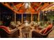 Enclosed outdoor living space featuring wicker furniture, overhead heating, a ceiling fan, and a central fire pit at 10914 Remmick Ridge Rd, Parker, CO 80134
