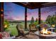 Comfortable screened-in porch with fire pit, cushioned chairs, and serene views of the surrounding landscape at dusk at 10914 Remmick Ridge Rd, Parker, CO 80134