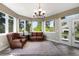 Inviting sunroom featuring comfortable seating, an ornate chandelier, and large windows showcasing beautiful views at 10914 Remmick Ridge Rd, Parker, CO 80134