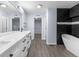 Bright bathroom featuring double sinks, white marble countertops, black hardware, and a modern soaking tub at 1963 Hogan Ct, Castle Rock, CO 80109