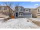 Charming two-story home with a covered front porch, shutters, and a two-car garage on a snow covered lot at 1963 Hogan Ct, Castle Rock, CO 80109
