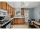 Traditional kitchen with wood cabinets, stainless steel appliances, and dining area at 3975 S Jason St, Englewood, CO 80110