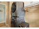 Convenient laundry room with gray stacked washer and dryer and cabinet storage at 3975 S Jason St, Englewood, CO 80110