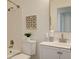 Bathroom featuring a white vanity, toilet, and a shower with white subway tiles at 3854 S Olathe Cir, Aurora, CO 80013