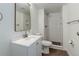 This bathroom offers a tiled shower, a white vanity, and a modern mirror at 3854 S Olathe Cir, Aurora, CO 80013