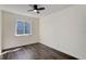 This bedroom features dark wood floors, a ceiling fan, and a bright window at 3854 S Olathe Cir, Aurora, CO 80013