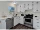 Modern kitchen featuring stainless steel appliances, white cabinets, and sleek countertops at 3854 S Olathe Cir, Aurora, CO 80013