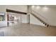 Bright open floor plan with stairs, laminate flooring, and view of kitchen at 12164 E Amherst Cir, Aurora, CO 80014