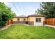 Spacious backyard featuring a well-maintained lawn, brick accents, and a privacy fence at 2255 Perry St, Denver, CO 80212