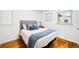 This bedroom features wood floors, a gray headboard, and a window with natural light at 2255 Perry St, Denver, CO 80212