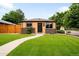 Charming brick home featuring a well-manicured lawn and inviting walkway leading to a dark front door at 2255 Perry St, Denver, CO 80212