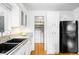 White cabinets with gray granite countertops contrast with the black sink and refrigerator at 2255 Perry St, Denver, CO 80212