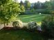 Picturesque backyard with white picket fence overlooks a tranquil pond and lush green lawn at 10433 Red Mountain W, Littleton, CO 80127