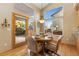 Charming dining area with a round table, four chairs, and a view of the backyard through large windows at 735 Orchard Ct, Louisville, CO 80027