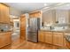 Spacious kitchen with modern stainless steel refrigerator, wooden cabinets, and granite countertops at 735 Orchard Ct, Louisville, CO 80027