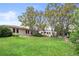 Spacious backyard featuring green grass, mature trees, landscaping and detached garage at 2020 Routt St, Lakewood, CO 80215
