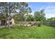 Large back yard featuring grass, mature trees, garden beds, landscaping, storage shed, and wood fence at 2020 Routt St, Lakewood, CO 80215